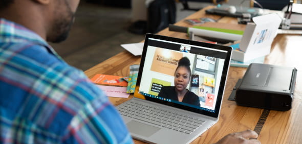 A man engaged in a video chat on his laptop, focused and interacting with someone on the screen.