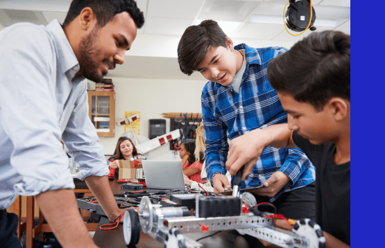 A diverse group of students collaboratively building and programming a robot in a classroom setting.